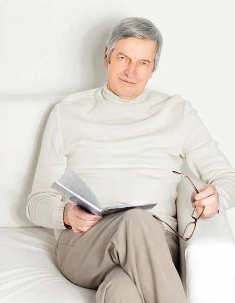 Dijital tablet bir sandalyede oturan yaşlı adam. — Stok fotoğraf
