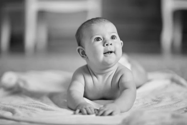 Leuke baby liggend op de deken en opzoeken — Stockfoto