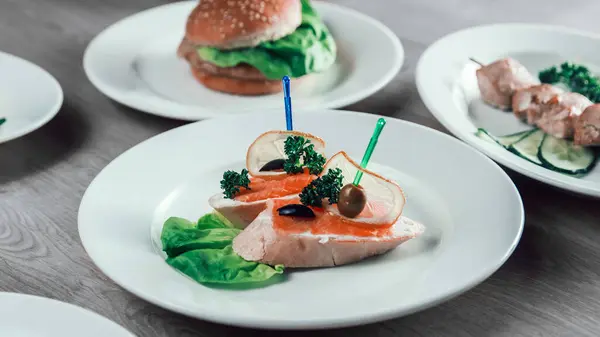 Aperitief met gezouten zalm en andere gerechten op tafel. — Stockfoto