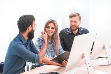 Ofisteki toplantıda neşeli çalışanlar bir şey tartışıyorlar.