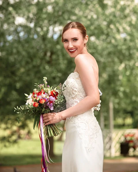 サイドビュー。結婚式の花束を持つ幸せな花嫁. — ストック写真
