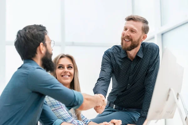 Jóvenes profesionales estrechando las manos en el lugar de trabajo — Foto de Stock