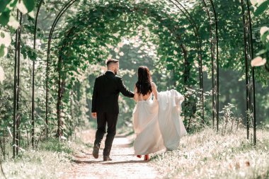 rear view. happy bride and groom passing under the wedding arch.