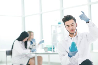 yakın çekim. genç bilim adamı sıvı analizi şişeye yapar.