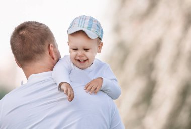Bir Sunny parkta duran küçük oğluyla mutlu baba.