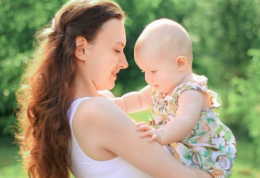 Anne ve mutlu kızı parkta bir yürüyüş üzerinde gülümseyen