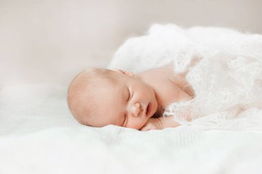 Yeni doğmuş bebek karnının üstünde yatar ve başını tutmayı öğrenir.