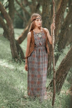 Genç hippi kadın ormanda yürüyüş uzun bir sopa ile