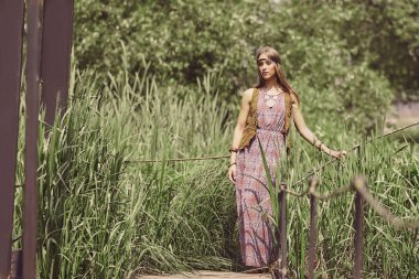 güzel hippi kız parkta bir ahşap köprü ayakta