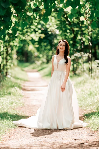 Retrato de novia hermosa de pie en el parque de la ciudad . — Foto de Stock