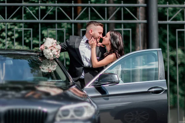 Doe dicht. bruid en bruidegom staan naast de auto — Stockfoto