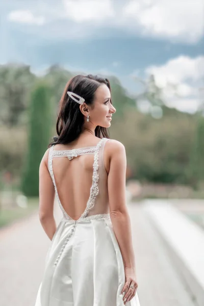 Bella donna in abito da sposa su sfondo natura — Foto Stock