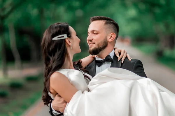 Marié heureux porte la mariée dans ses bras — Photo