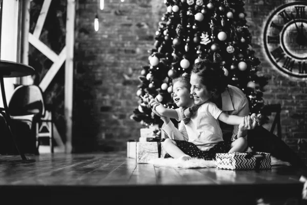 Anne kızı ile oynar, Noel ağacının yanında oturan — Stok fotoğraf