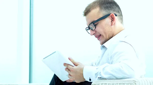 Jovem navegando arquivos de mídia em seu tablet — Fotografia de Stock