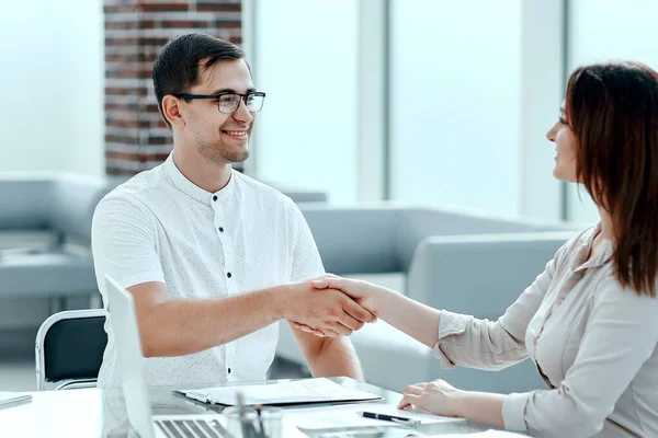 Handshake of a businessman and businesswoman sitting at office Desk — Stock Photo, Image