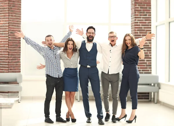 Πολύ χαρούμενη επιχειρηματική ομάδα στέκεται σε ένα φωτεινό γραφείο — Φωτογραφία Αρχείου