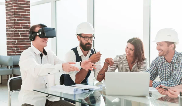 young designer uses virtual reality glasses at a meeting in the office.