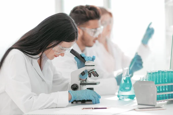 Zblízka. vědci a laboratorní pracovníci sedící na laboratorním stole — Stock fotografie