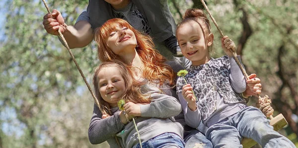Gran familia feliz balanceo en columpios de jardín —  Fotos de Stock