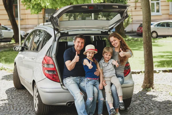 가족 가족 자동차의 트렁크에 앉아서 손가락 표시 — 스톡 사진
