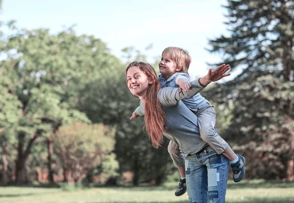 Feliz mamá y su hijo en un paseo por el parque de verano —  Fotos de Stock