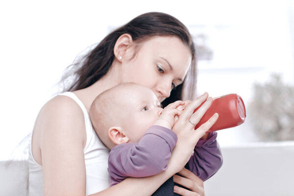 caring young mother feeds the baby. the concept of motherhood
