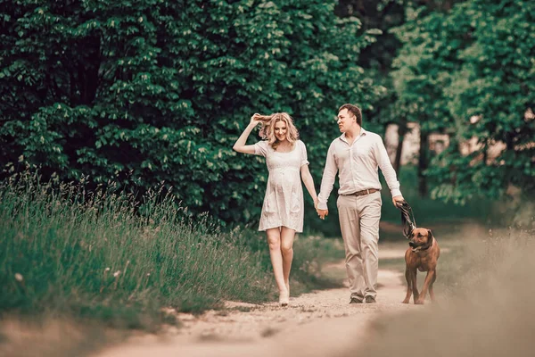 Ung familj och deras sällskapsdjur promenader längs sökvägen i parken — Stockfoto