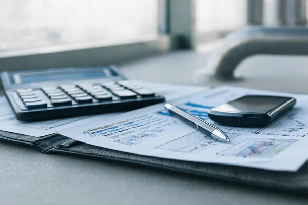 Mobiltelefon und Finanzdokumente auf dem Desktop. — Stockfoto