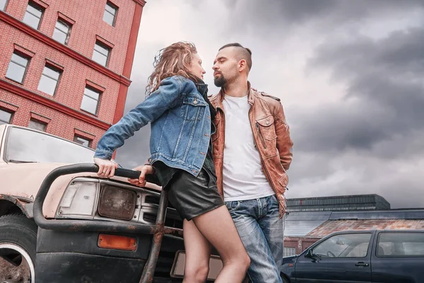 Молодая влюбленная пара, стоящая возле машины в городе — стоковое фото