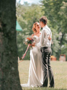 Şehir parkında çimlerin üzerinde duran güzel bir çift.