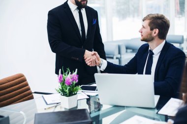 Modern bir ofiste iş arkadaşları arasında tokalaşma