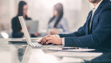 Modern bir ofisteki işyerinde finansal verilerle çalışan başarılı bir iş adamı..