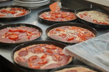 Pizzacının mutfak masasında pizzalı bir sürü şekil var. .