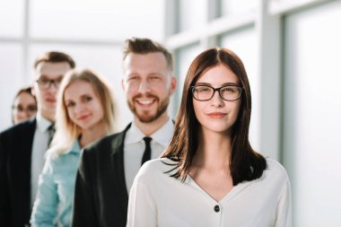 Kapat. İş adamlarının önünde kendine güvenen bir iş kadını duruyor..