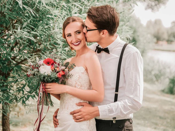 Happy bride and groom on a walk in the city Park — Zdjęcie stockowe