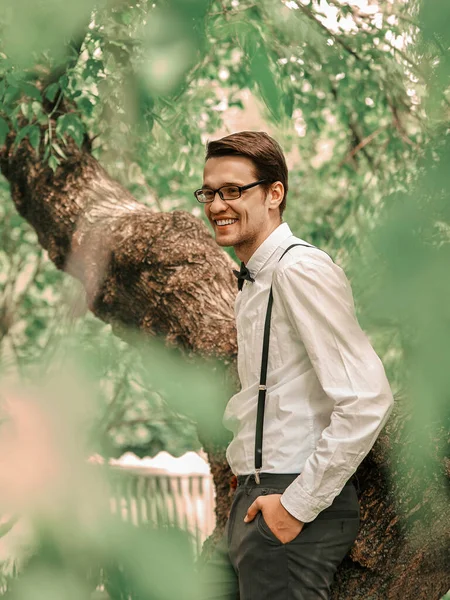 Χαρούμενος αρραβωνιαστικός που στέκεται ανάμεσα στα δέντρα στον ανοιξιάτικο κήπο. — Φωτογραφία Αρχείου