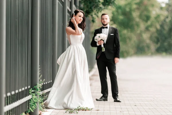 Brud och brudgum står på en stadsgata. — Stockfoto