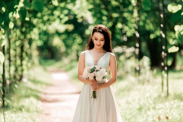 Portrait d'une mariée heureuse debout sous une arche dans le parc — Photo