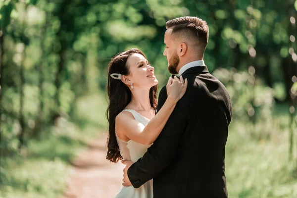 Feliz novia y novio de pie bajo el arco de la boda —  Fotos de Stock