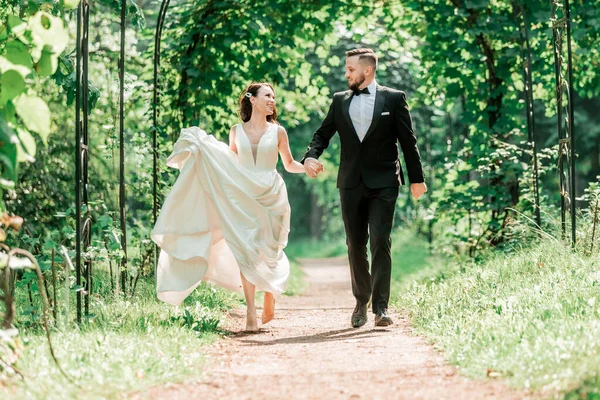 Rear view. happy bride and groom passing under the wedding arch. — Stock Fotó