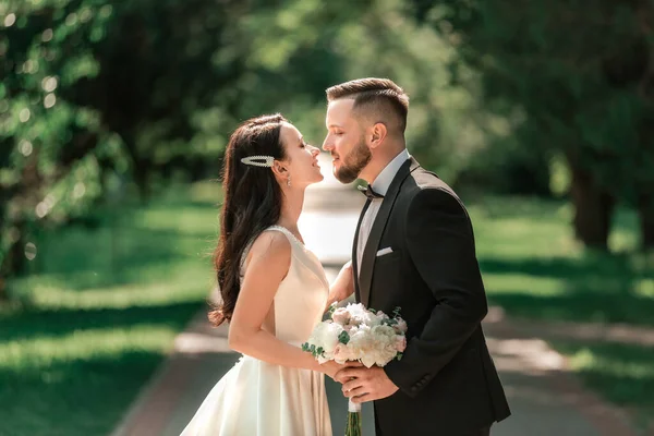 Loving couple of newlyweds standing on a Park alley — ストック写真