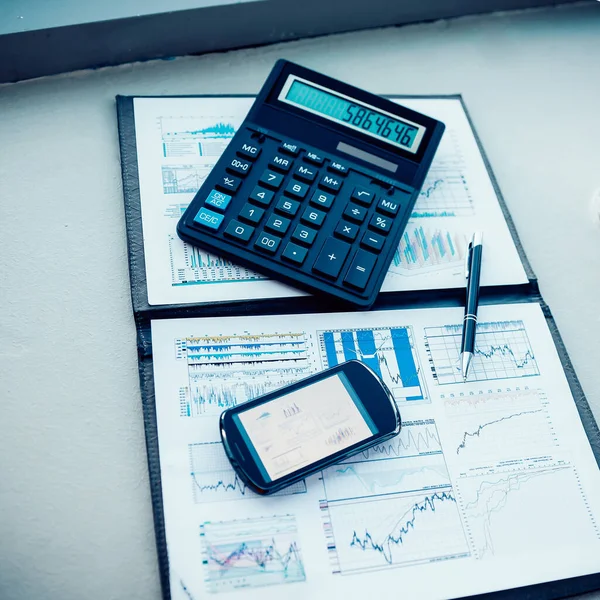 Calcolatrice, smartphone e documenti finanziari sul Business Desk — Foto Stock
