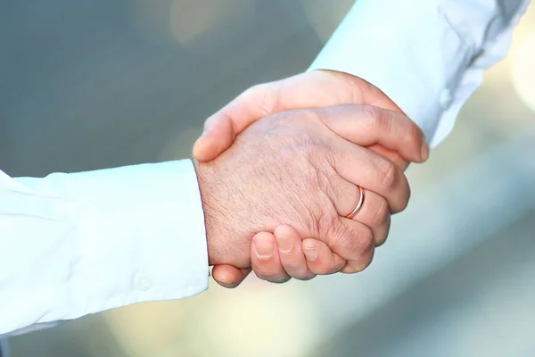 Närbild. Handshake affärsmän i suddig bakgrund. — Stockfoto