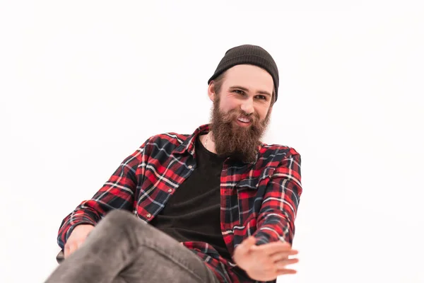 Bebaarde hipster in een geruit hemd legt iets uit aan zijn gesprekspartner. — Stockfoto