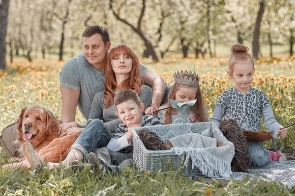 Família moderna com crianças em um piquenique em um dia de primavera — Fotografia de Stock