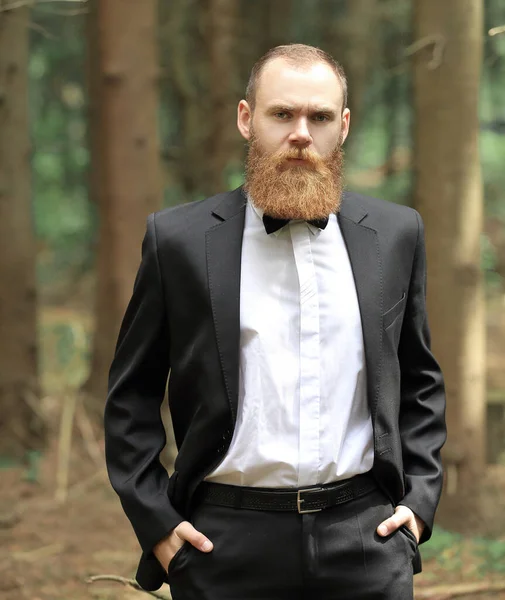 Portrait of a confident businessman on a background of trees in the forest — Stock Photo, Image