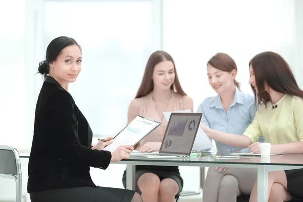 Erwachsene Geschäftsfrau und Gruppe junger Mitarbeiter am Schreibtisch — Stockfoto