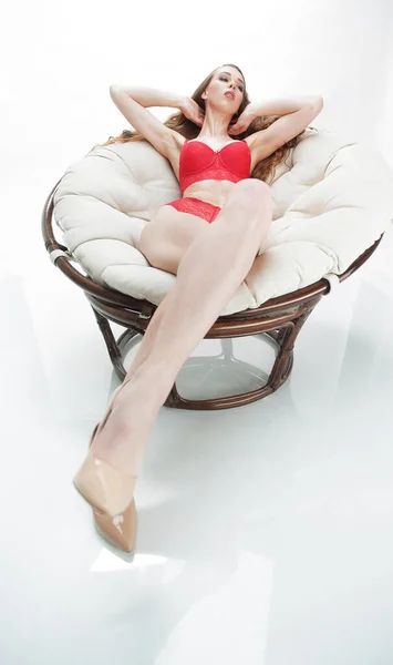 Schöne Frau in roter Unterwäsche entspannt in einem runden Stuhl papasan .photo mit Kopierraum — Stockfoto