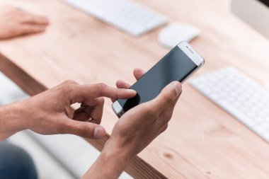 close up. businessman uses his smartphone in the workplace.